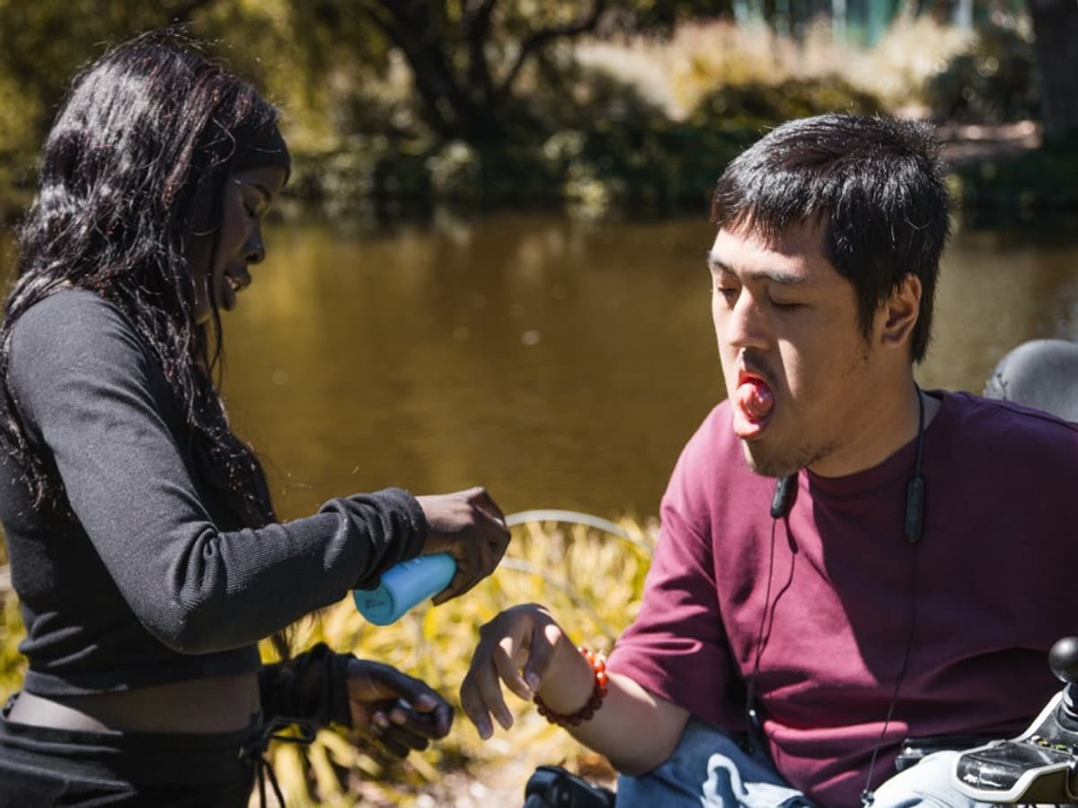Compassionate support worker providing gentle outdoor personal care and assistance for a client